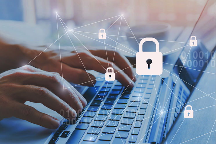 Hands typing on a laptop keyboard. There are lock icons floating around the image.