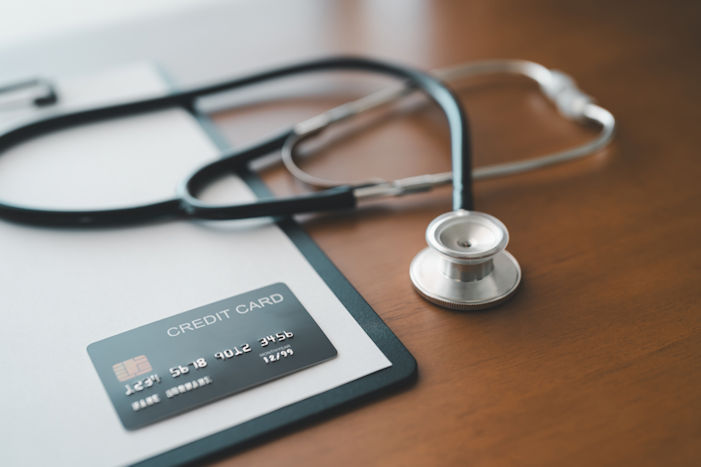 A stethoscope and credit card laying on a patients medical form.